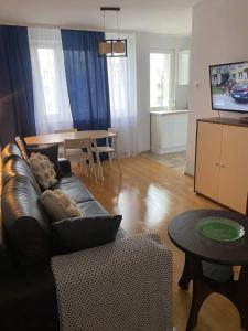a living room with a black couch and a table at Take a break apartment in Ustka