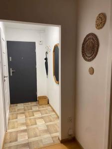 een hal met een zwarte deur en een houten vloer bij Take a break apartment in Ustka