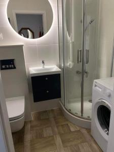 a bathroom with a shower and a toilet and a sink at Take a break apartment in Ustka