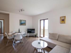 a living room with a couch and a table at Spacious apartment with private terrace in Pridvorje
