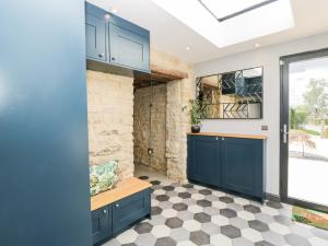 a kitchen with blue cabinets and a checkered floor at Suncroft in Cheltenham