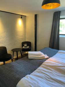 - une chambre avec un lit, deux chaises et une table dans l'établissement Backadal Gård BnB, à Ystad