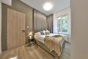 een slaapkamer met een groot bed en een raam bij Chalupku - Luxurious apartment 70m2 in direct centrum with parking included, Air-conditioned, balcony, quiet sleep, best in town in Banská Bystrica