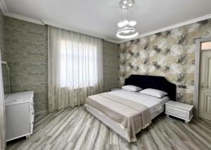 a bedroom with a bed and a large window at Qafqaz Manor Napoli in Gabala