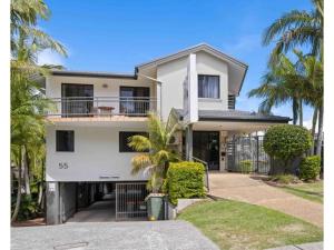 een wit huis met palmbomen ervoor bij Beachfront Apartments in Port Macquarie