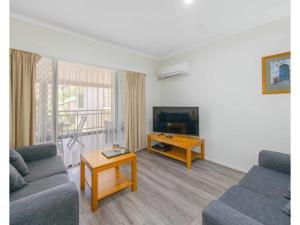 een woonkamer met een bank en een tafel bij Beachfront Apartments in Port Macquarie
