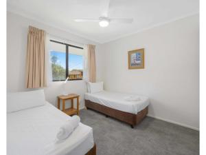 een slaapkamer met 2 bedden en een raam bij Beachfront Apartments in Port Macquarie