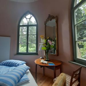 a bedroom with a bed and a table with a mirror at Rapunzel trifft Dornröschen in Schweizermühle