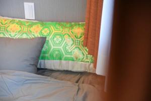 東京にあるHotel Tokyo Hub - Vacation STAY 27684vのベッド(オレンジ色のカーテン、枕付)