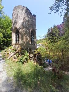 an old stone building on the side of a road at Rapunzel trifft Dornröschen in Schweizermühle