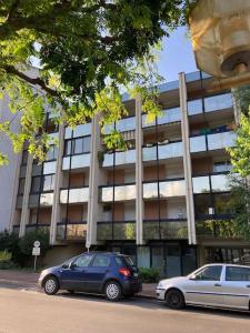 zwei Autos vor einem Gebäude geparkt in der Unterkunft Studio au cœur de chatelguyon in Châtel-Guyon