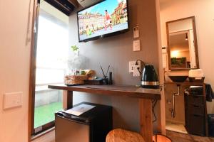 a kitchen with a counter with a television on the wall at Hotel Tokyo Hub - Vacation STAY 27692v in Tokyo