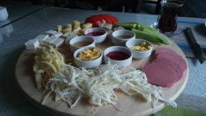 a plate of food with cheese and other foods on a table at Campy Mountain Campsite in Tkhit