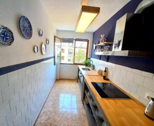 una cocina con paredes azules y blancas y fregadero en Altea Old Town PRECIOSO, en Altea