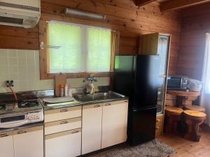 Log house Hata - Vacation STAY 29001v في شيما: مطبخ مع ثلاجة سوداء ومغسلة