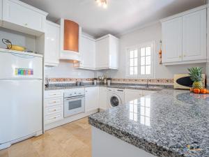 a kitchen with white cabinets and a granite counter top at CASA DE FLAMENCO in Orihuela Costa +17 photos