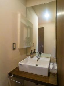 een badkamer met een witte wastafel en een spiegel bij At the foot of Nasu, an old private house remodele - Vacation STAY 15220 in Nasushiobara