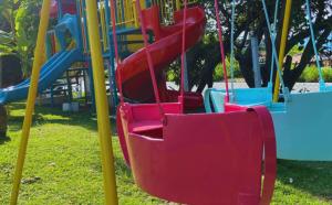 - un toboggan rouge sur une aire de jeux dans un parc dans l'établissement Pousada Jovimar, à Aparecida