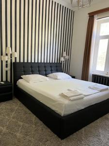 - une chambre avec un grand lit et une tête de lit noire dans l'établissement Guest House Pirosmani 60, à Sighnaghi