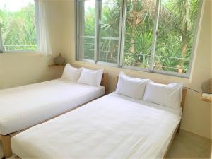 zwei Betten in einem Zimmer mit zwei Fenstern in der Unterkunft Blue cave Blue in Green - Vacation STAY 31673v in Fukai