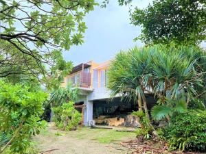 ein Haus mit Palmen davor in der Unterkunft Blue cave Blue in Green - Vacation STAY 31673v in Fukai