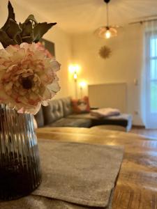 a vase with flowers on a table in a living room at Zum Loderwinkl in Sankt Englmar