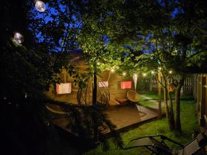 a backyard lit up at night with lights at Pilsētas glempings - "Gliemezis" in Valmiera