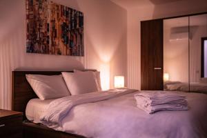 1 dormitorio con 1 cama grande con sábanas blancas en Designer 3 Bedroom / Bathroom Apartment in Swatar., en Birkirkara