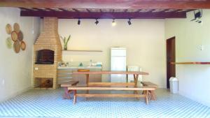 eine Küche mit einem Tisch und einer Bank in einem Zimmer in der Unterkunft Condomínio Colibri ER Hospedagens in Barra de São Miguel