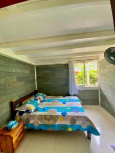 a bedroom with a bed and a window at Casa de Vacaciones ECOWASI VERAS in Capurganá