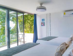 a bedroom with two beds and a large window at Tres Piedras 
