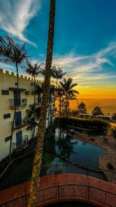 a view of a building with a pool and palm trees at SR Boutique Hotel in São Pedro