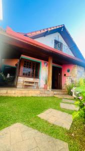 a house with a green lawn in front of it at Hostel LARes in Brumadinho