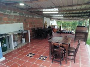 een patio met tafels en stoelen en een bakstenen muur bij FINCA YAJARI in Papagalleros