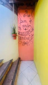 a door with a sign on the side of a building at Hostel LARes in Brumadinho