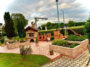 un jardín con un patio de ladrillo con un horno de pizza en Hotel Zéta, en Lenti