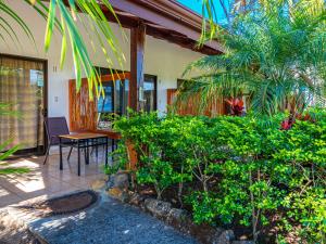 une terrasse couverte d'une maison avec une table et quelques plantes dans l'établissement Hotel Colinas del Sol, à Atenas