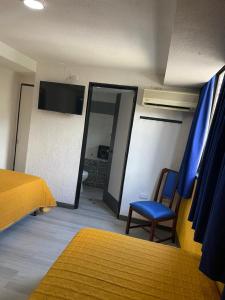 1 dormitorio con espejo, 1 cama y 1 silla en Hotel Renovación, en Caracas