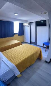 um quarto de hotel com duas camas e cortinas azuis em Hotel Renovación em Caracas