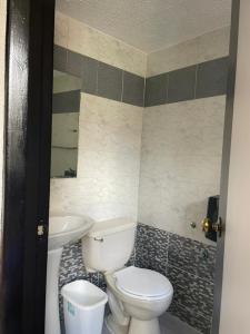 een badkamer met een toilet en een wastafel bij Hotel Renovación in Caracas