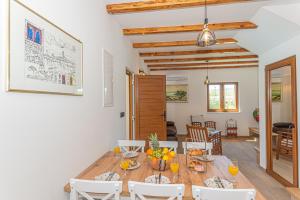 una cucina e una sala da pranzo con tavolo e sedie in legno di Casa del sol a Južni Škugori