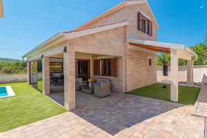 una riproduzione di una casa con patio di Casa del sol a Južni Škugori