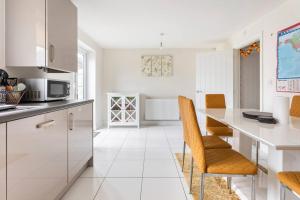 a kitchen with white cabinets and a table and chairs at Double bedroom with a private bathroom in Woodplumpton