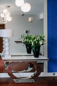 Dos plantas sobre una consola con lámpara. en Willa Plażowa, en Międzyzdroje