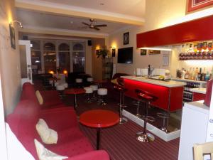 um bar com cadeiras vermelhas e um balcão vermelho em The Norwood em Blackpool