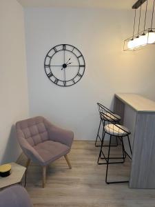 a living room with a chair and a clock on the wall at SMILJANA in Banja Koviljača