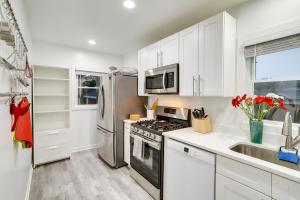 a kitchen with white cabinets and stainless steel appliances at South Haven Oasis - Private Hot Tub, Pool and Grill! in South Haven