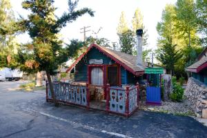 a small blue building with a gate in the street at Castle Wood Theme Cottages- COUPLES ONLY in Big Bear Lake