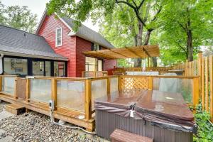 a wooden deck with a table and a house at South Haven Oasis - Private Hot Tub, Pool and Grill! in South Haven