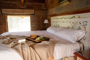ein Schlafzimmer mit einem Bett und einem Tablett mit Essen drauf in der Unterkunft EL TORREAL in Cayambe